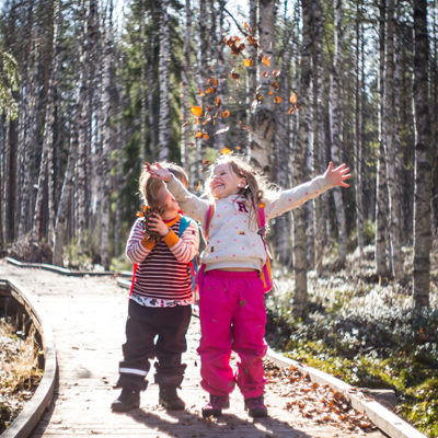 Iloiset lapset ruskaisella luontopolulla.